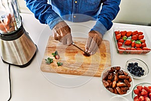 Senior man cutting datil at kitchen photo