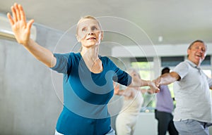 Senior man dances steamy salsa with elderly female companion for fitness classes photo