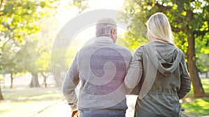 Senior man, daughter and walking outdoor at a park with love, care and support for health and wellness. A elderly male