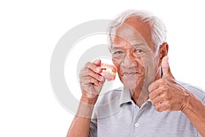 Senior man with denture, giving thumb up photo