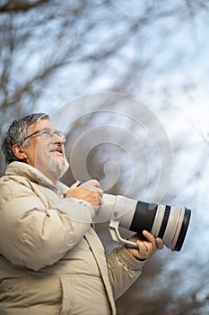 Senior man devoting time to his favorite hobby - photography photo