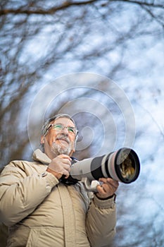 Senior man devoting time to his favorite hobby - photography photo