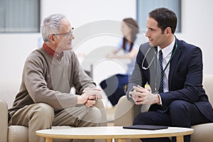 Senior Man Discussing Test Results With Doctor