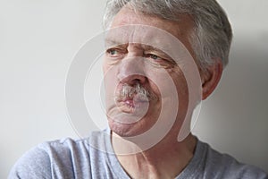 Senior man distorts his mouth