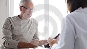 Senior man and doctor with tablet pc at hospital 51