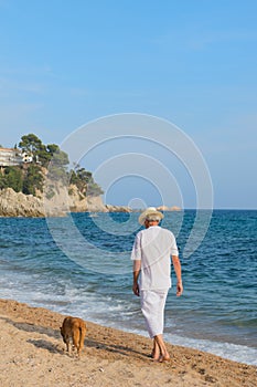 Senior man with dog at the beach