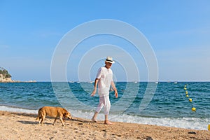 Senior man with dog at the beach