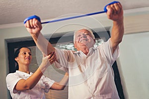 Senior man doing exercises using a strap