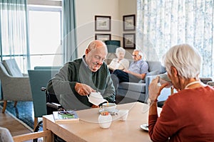 Senior man drinking hot tea with his wife at retirement community