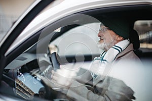 Senior man driving a car, close up.