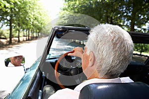 Senior man driving sports car