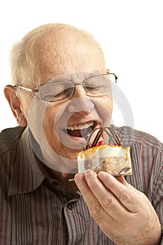 Senior man eating a cake