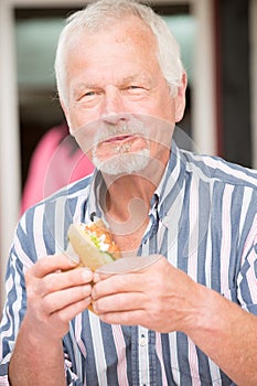Senior man eating fish
