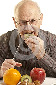 Senior man eating fresh fruit