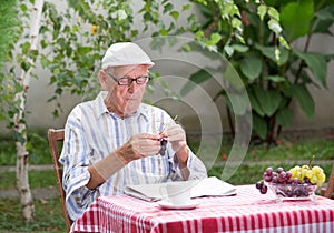 Senior man eating grape