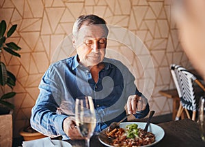 Senior man eating healthy and nutrition food at restaurant happy, satisfied and at table. Alone, elderly male and