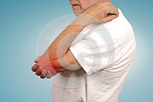 Senior man with elbow inflammation colored in red suffering from pain photo