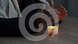 Senior man without electricity at home with candle, hands close-up. Shutdown of heating and electricity, power outage