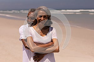 Senior man embracing senior woman on beach