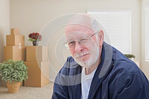 Senior Man in Empty Room with Packed Moving Boxes
