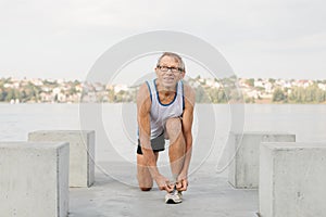 senior man is engaged in sports on the lake embankment