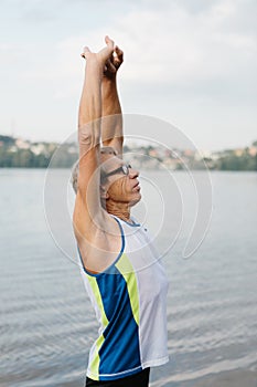 senior man is engaged in sports on the lake embankment