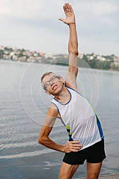 senior man is engaged in sports on the lake embankment