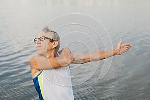 senior man is engaged in sports on the lake embankment