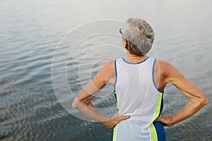 senior man is engaged in sports on the lake embankment