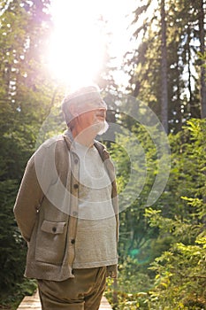 Senior man enjoying the outdoors walking throught lovely nature