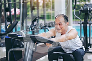 Senior man exercise on cycling machine in fitness center