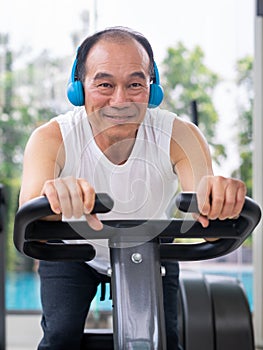 Senior man exercise on cycling machine in fitness center