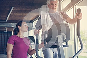 Senior man exercising on stationary bikes.