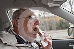 Senior man with expressive face eating  fast foods