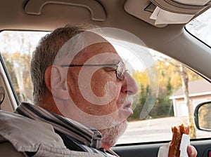 Senior man with expressive face eating  fast foods
