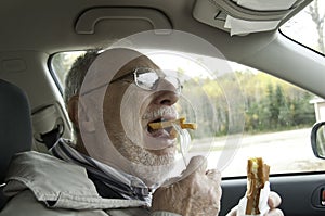 Senior man with expressive face eating fast foods