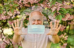 Senior man face mask. Respiratory mask. Pollen allergen. Man and flowers. Allergic reaction. Limit risk infection