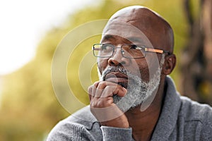 Senior man, face and thinking outdoor in nature to remember memory, idea or vision. Headshot of an elderly African male