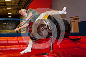 Senior Man Falls Off Mechanical Bull photo