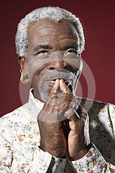 Senior Man With Fingers On Mouth