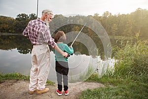 Senior man fishing with his grandson