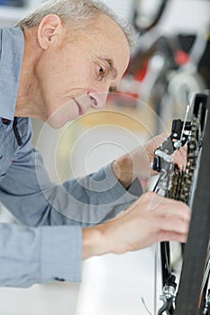 Senior man fixing bike wheel