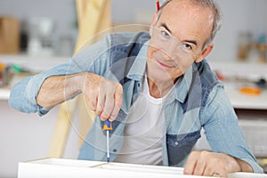 Senior man fixing furniture