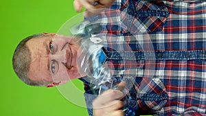 Senior man folding plastic bottle and compressing it for recycling.