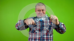 Senior man folding plastic bottle and compressing it for recycling.