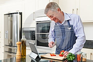 Senior Man Following Recipe On Digital Tablet