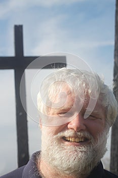 Senior Man in Front of a Cross