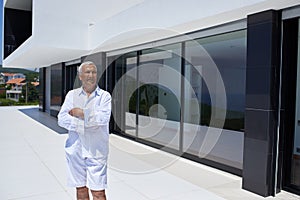 Senior man in front of modern home