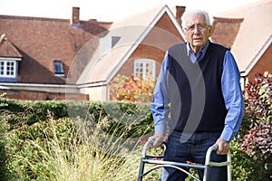 Senior Man In Garden Using Walking Frame