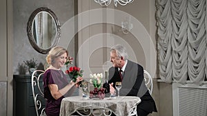 Senior man giving bouquet of flowers to his wife